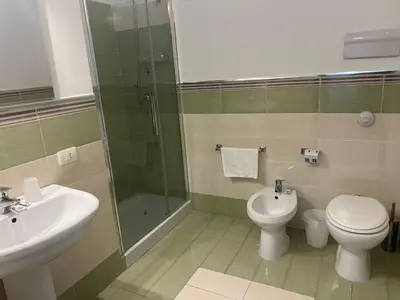 a bathroom with a sink and a toilet and a shower at Central Station in Palermo