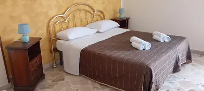 a bedroom with a bed and a yellow wall at Apartament di Nick Central Station No ZTL in Palermo