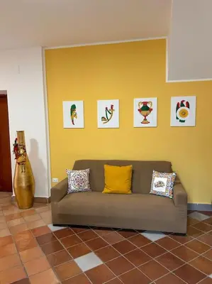 a couch in a room with a yellow wall at Ai Pupi Siciliani in Palermo
