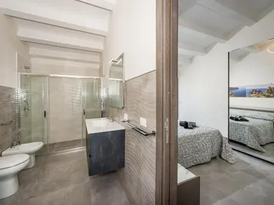 a bathroom with a sink and a toilet and a bed at Villa Rocchi Livreri by Interhome in Scopello