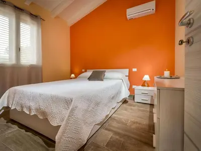 a bedroom with an orange wall and a bed at Villa Mari e Monti by Interhome in Castellammare del Golfo