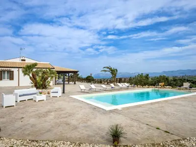 a swimming pool with lounge chairs and a house at Villa Mari e Monti by Interhome in Castellammare del Golfo