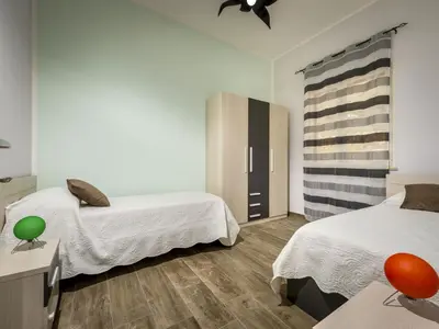 a bedroom with two beds and a dresser with a mirror at Villa Mari e Monti by Interhome in Castellammare del Golfo