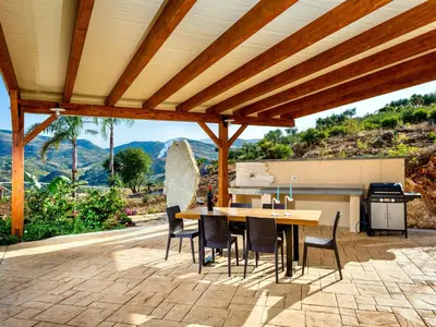 a patio with a table and chairs and a grill at Villa Le Muse by Interhome in Scopello