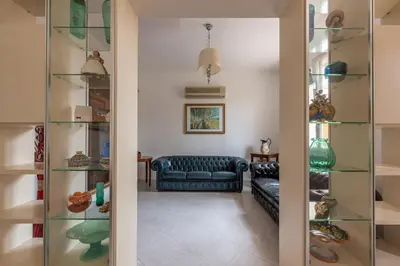 a living room with glass shelves and a couch at Villetta Ficarazzi by Wonderful Italy in Ficarazzi