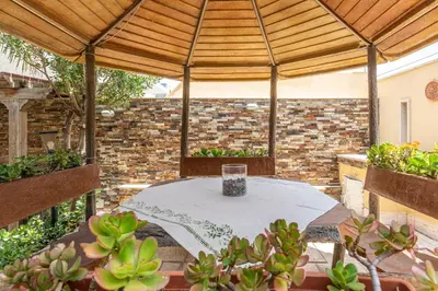 a patio with a table under a wooden pergola at Villetta Ficarazzi by Wonderful Italy in Ficarazzi