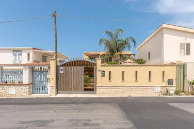 a building with a gate in front of a house at Villetta Ficarazzi by Wonderful Italy in Ficarazzi
