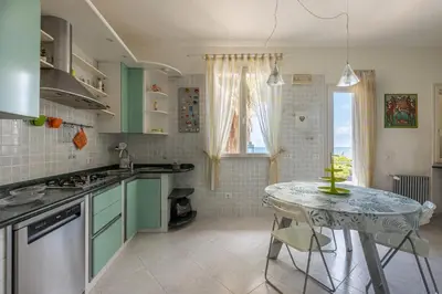 a kitchen with green cabinets and a table in it at Villetta Ficarazzi by Wonderful Italy in Ficarazzi