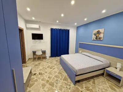 a bedroom with a bed and a blue wall at Casa Vera in Piana degli Albanesi