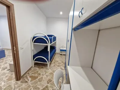 a small room with a blue chair and a mirror at Casa Vera in Piana degli Albanesi