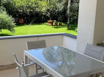 a glass table and chairs on a balcony at Villa Lucia in Palermo