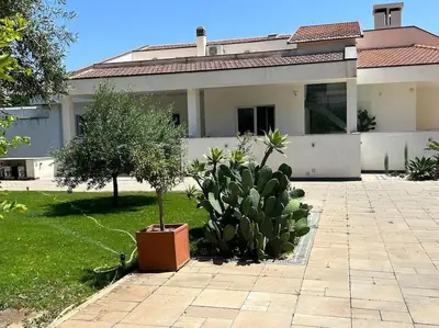 a house with a potted tree in the yard at Villa Lucia in Palermo