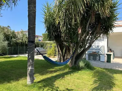 a hammock hanging from a palm tree in a yard at Villa Lucia in Palermo