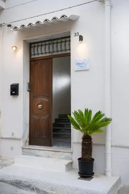 a front door of a house with a potted plant at MamErì central rooms in Castellammare del Golfo