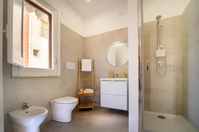 a bathroom with a toilet and a sink and a mirror at MamErì central rooms in Castellammare del Golfo