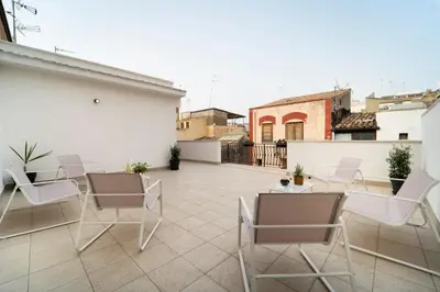 a patio with chairs and tables on a roof at MamErì central rooms in Castellammare del Golfo