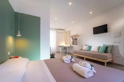 a bedroom with a bed and two towels on the floor at MamErì central rooms in Castellammare del Golfo