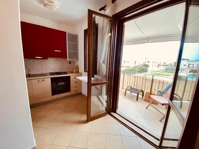 a kitchen with a sliding glass door leading to a balcony at Amarena Casa Vacanze in San Vito lo Capo