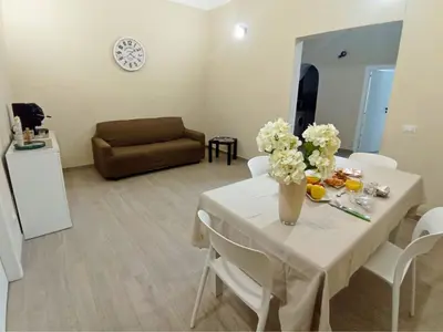 a living room with a table with flowers and a couch at Mille Memories Apartment in Palermo