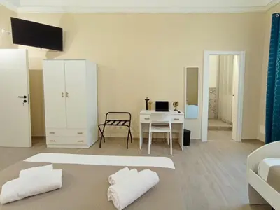 a white room with a bed and a desk at Mille Memories Apartment in Palermo