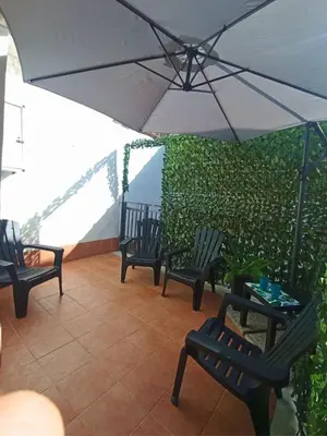 a group of chairs and an umbrella on a patio at Mille Memories Apartment in Palermo