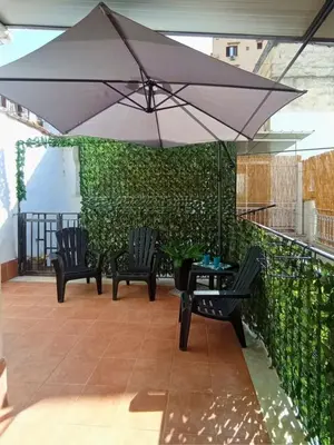 a patio with two chairs and an umbrella at Mille Memories Apartment in Palermo