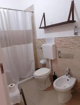 a bathroom with a white toilet and a sink at Villa Buscemi in Bagheria