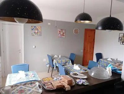 a dining room with a table and blue chairs at Villa Buscemi in Bagheria