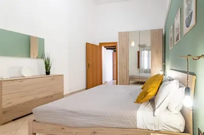 a bedroom with a large bed with a wooden headboard at GuestHost - Your Home at the Cathedral - Palermo Cozy Flat in Palermo