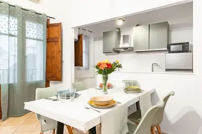 a white dining room with a white table and chairs at GuestHost - Your Home at the Cathedral - Palermo Cozy Flat in Palermo