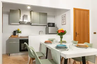 a kitchen and dining room with a white table and chairs at GuestHost - Your Home at the Cathedral - Palermo Cozy Flat in Palermo