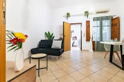 a living room with a black couch and a table at GuestHost - Your Home at the Cathedral - Palermo Cozy Flat in Palermo