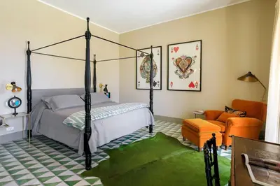 a bedroom with a four poster bed and a chair at Trinacria Luxury Suite in Palermo