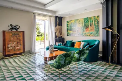 a living room with a green couch and a table at Trinacria Luxury Suite in Palermo