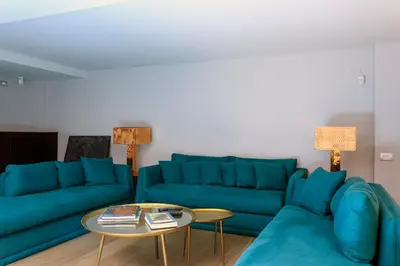 a living room with blue couches and a table at Trinacria Luxury Suite in Palermo
