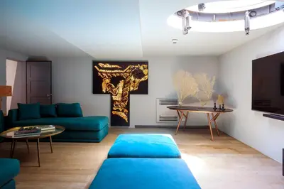 a living room with a blue couch and a table at Trinacria Luxury Suite in Palermo