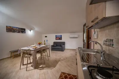 a kitchen and living room with a table and a couch at Sofia Rooms in Castellammare del Golfo