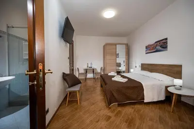 a bedroom with a bed and a bathroom with a shower at Sofia Rooms in Castellammare del Golfo