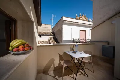 a balcony with a bowl of fruit and a table at Sofia Rooms in Castellammare del Golfo