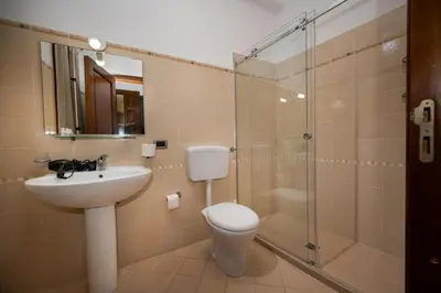 a bathroom with a toilet and a sink and a shower at Sofia Rooms in Castellammare del Golfo