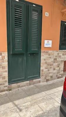 a green door on the side of a building at Alfa & Omega apartments in Palermo