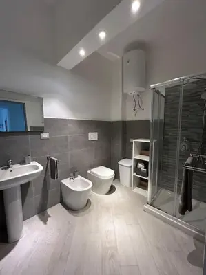 a bathroom with a toilet and a sink and a shower at Alfa & Omega apartments in Palermo