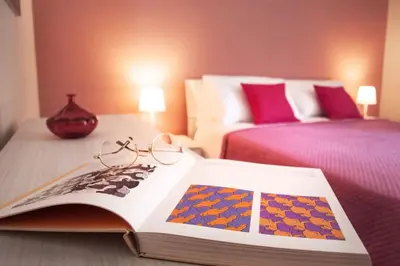 a book with glasses sitting on top of a bed at Corso Alberto in terrazza Palermo in Palermo