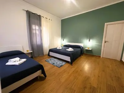 a bedroom with two beds and a green wall at Ai Papiri in Palermo