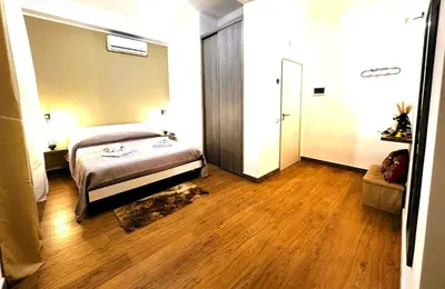 a bedroom with a bed and a wooden floor at Ai Papiri in Palermo