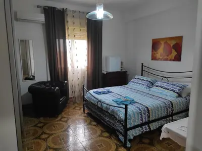 a bedroom with a bed and a chair at Camera a Palermo in Mondello