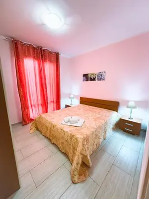 a bedroom with a bed and red curtains at Terrazza Bellini in Castellammare del Golfo