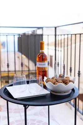 a table with a bottle of wine and two glasses at Terrazza Bellini in Castellammare del Golfo