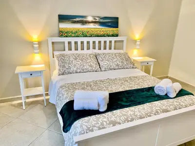a bedroom with a bed with two night stands and two tables at Central Apartment - Le Burnie in Palermo
