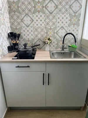 a kitchen with white cabinets and a sink at Dai Palermitani Rooms & Apartments in Palermo